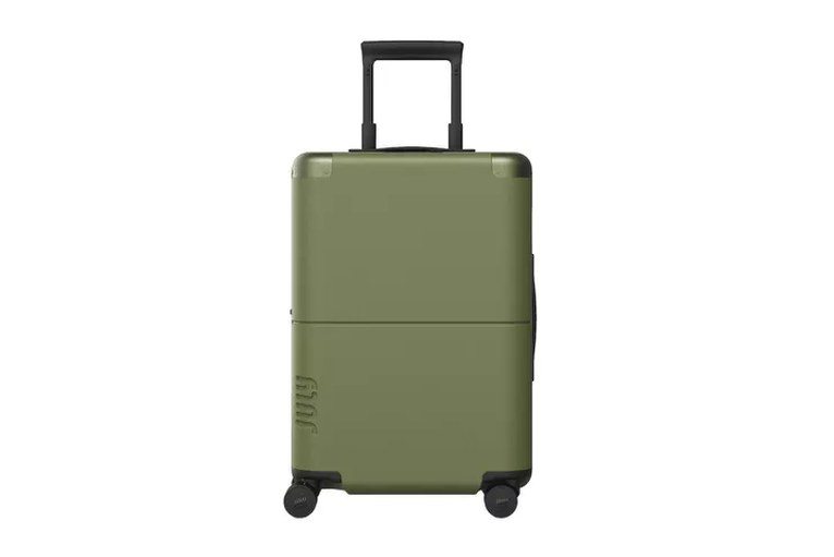 Monos checked bag being rolled through a terminal, motion blur on wheels