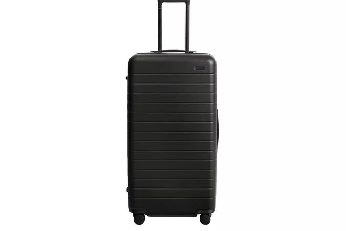 Open checked suitcase showing packed interior compartments and compression straps