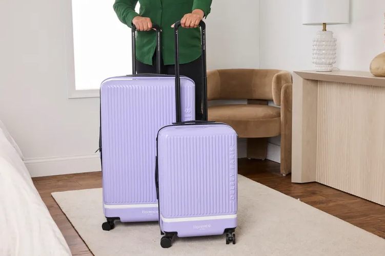two suitcases at baggage claim carousel, one red, one navy